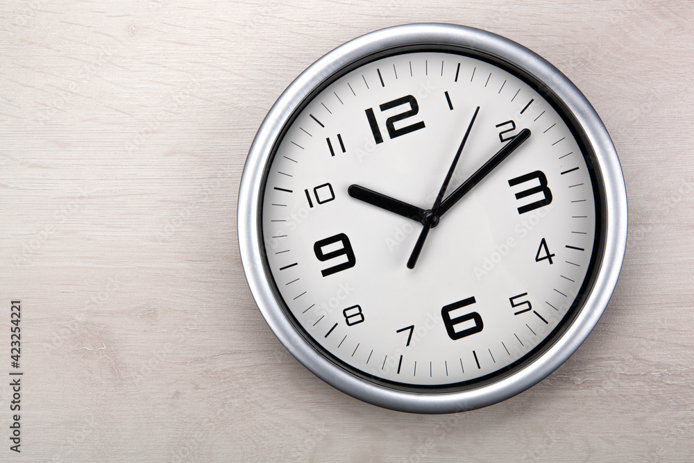 large white clock face with digits on a wooden background closeup large white clock face with digits on a wooden background closeup