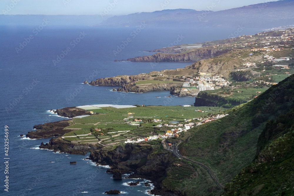 La costa norte de la isla de Tenerife, España. Paisaje costero típico de la isla volcánica donde se aprovechan las zonas menos escarpadas para la construcción de viviendas y cultivo de plátanos.
