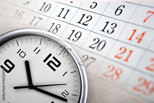 large white clock face with calendar sheets