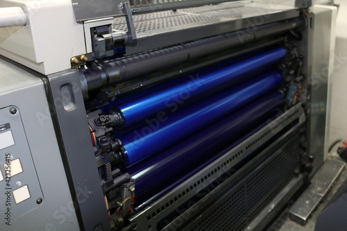 The blue painted roller system of the printing machine in Matbaa. Komori lithrone. selective focus