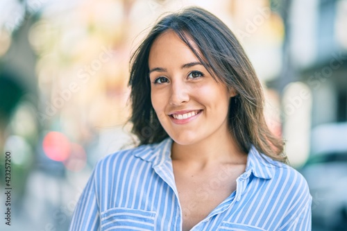 Young hispanic woman smiling happy standing at the city.