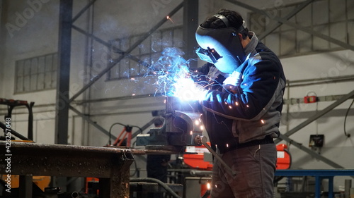 Man Welding Steel in Industrial Complex