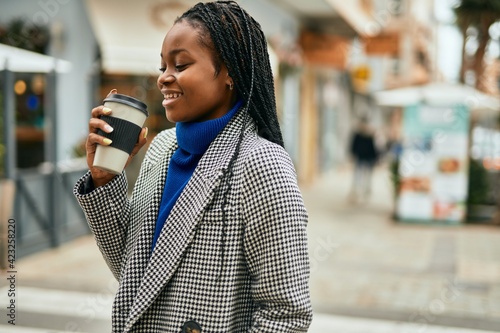 Young african american businesswoman smiling happy drinking coffee at the city.