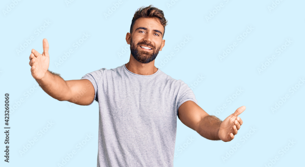 Young hispanic man wearing casual clothes looking at the camera smiling with open arms for hug. cheerful expression embracing happiness. Young hispanic man wearing casual clothes looking at the camera smiling with open arms for hug. cheerful expression embracing happiness.