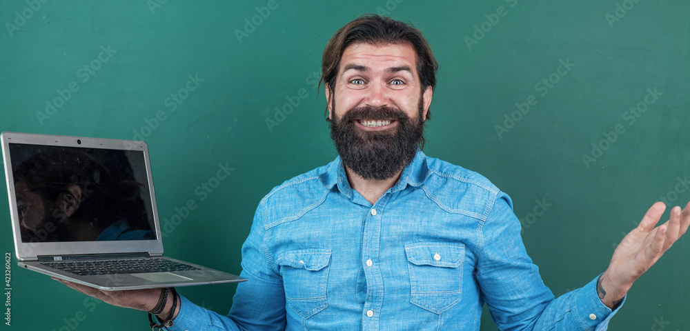formal online education. knowledge day. mature bearded teacher use laptop at lesson. brutal man work in classroom with blackboard. prepare for exam. college lecturer on lesson. back to school