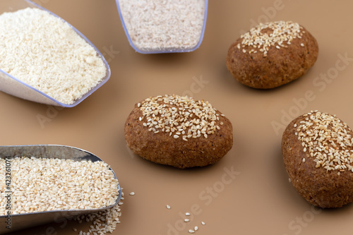 A healthy gluten-free keto bread made from almond flour and psyllium husk, sprinkled with sesame seeds. Baking ingredients in scoops. Ketogenic diet, paleo, low carb, high fat.