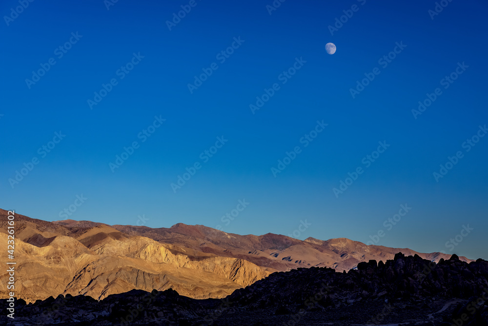 moon over mountains at sunrise