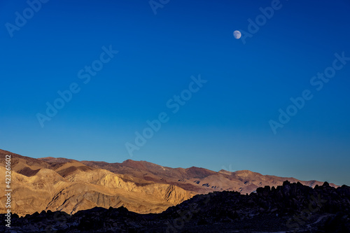 moon over mountains at sunrise