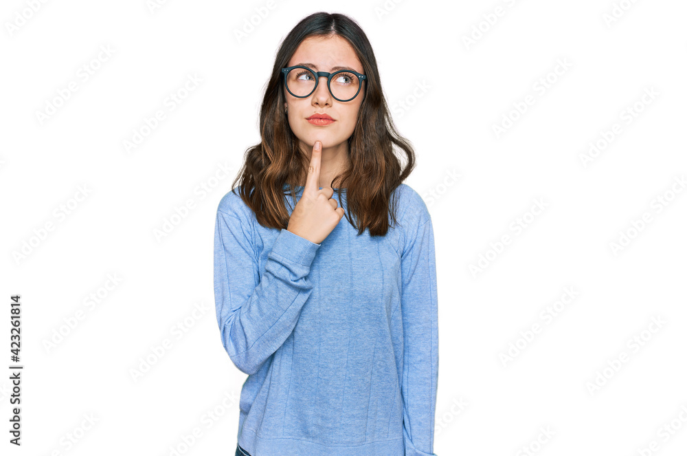 Young beautiful woman wearing casual clothes and glasses thinking concentrated about doubt with finger on chin and looking up wondering