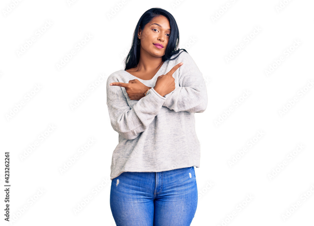 Hispanic woman with long hair wearing casual clothes pointing to both sides with fingers, different direction disagree Hispanic woman with long hair wearing casual clothes pointing to both sides with fingers, different direction disagree