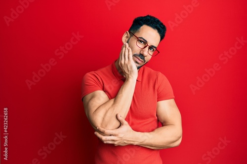 Young hispanic man wearing casual clothes and glasses thinking looking tired and bored with depression problems with crossed arms.