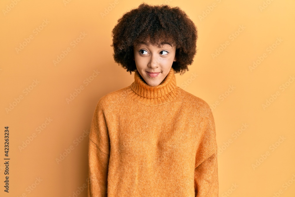 Young hispanic girl wearing wool winter sweater smiling looking to the side and staring away thinking. Young hispanic girl wearing wool winter sweater smiling looking to the side and staring away thinking.