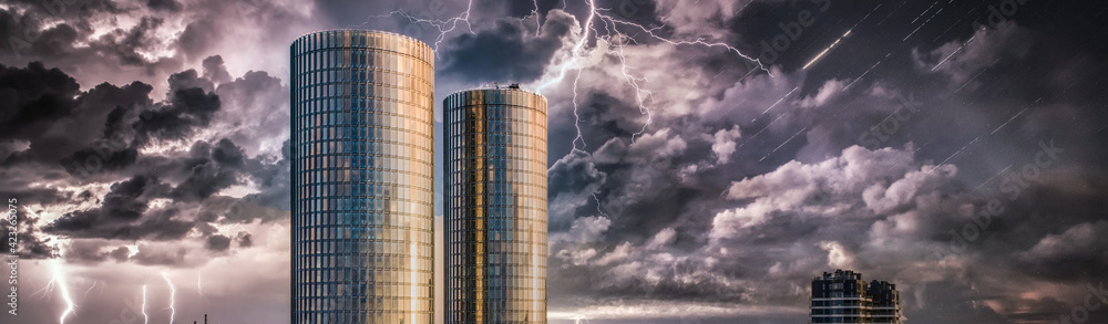 Urban architecture. Steel and glass facade of skyscrapers. Stormy sky.