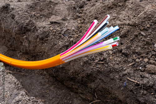 orange plastic cables for optical fiber, laid in an earth trench