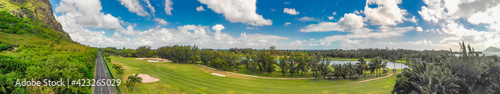 Golf course along a beautiful mountain and road, aerial panorama
