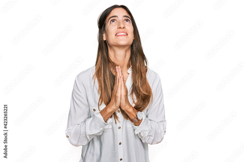 Young beautiful woman wearing casual clothes begging and praying with hands together with hope expression on face very emotional and worried. begging. Young beautiful woman wearing casual clothes begging and praying with hands together with hope expression on face very emotional and worried. begging.