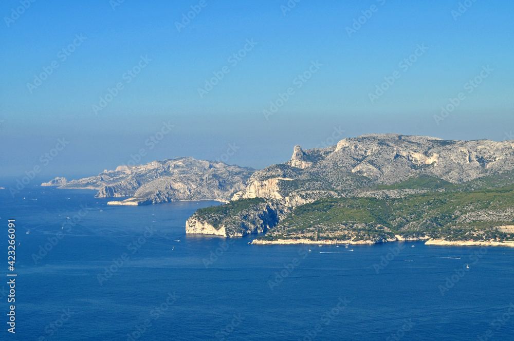Views of the blue sea, green shores and gray rocks in summer in France.