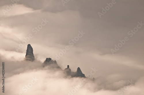 Jagged rock spires in clouds in Waterton-Glacier International Peace Park, Livingston Range, Montana      photo