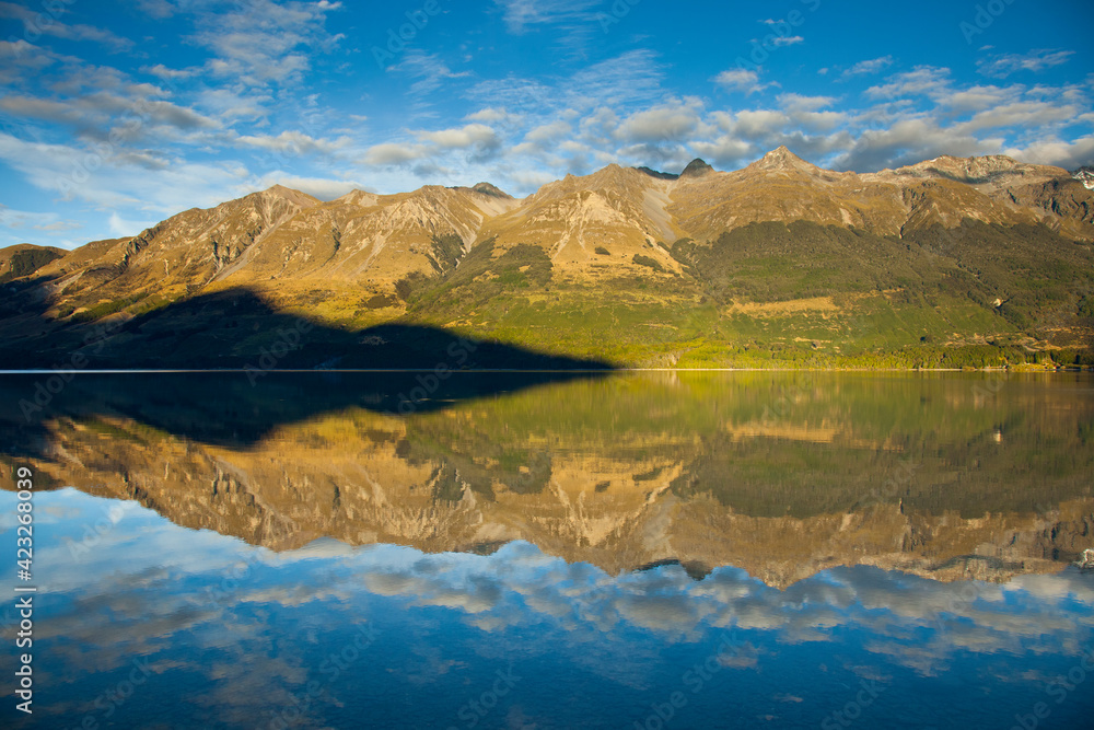 Early AM sun lights the high peaks of the Southern Alps creating mirror-like reflections on Lake Wakatipu near Glenorchy in New Zealand's South Island. Early AM sun lights the high peaks of the Southern Alps creating mirror-like reflections on Lake Wakatipu near Glenorchy in New Zealand's South Island.