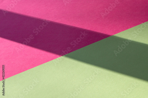 Macro image of green and pink paper with shadow effect and selective focus.