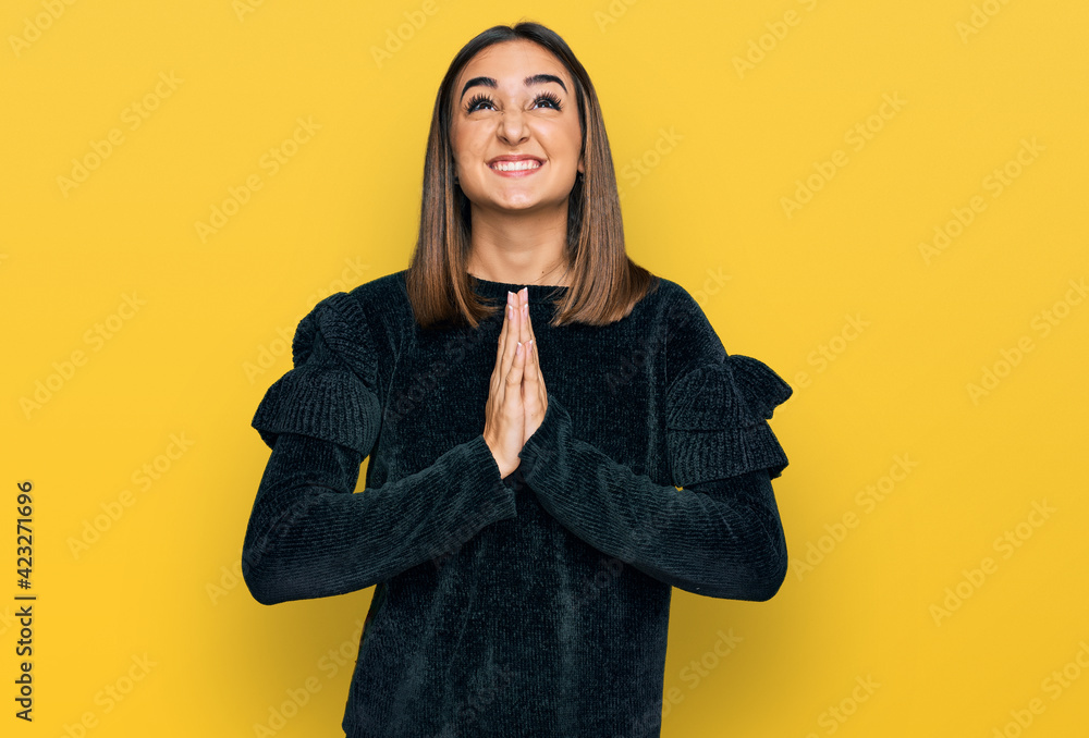 Beautiful brunette woman wearing elegant sweater begging and praying with hands together with hope expression on face very emotional and worried. begging. Beautiful brunette woman wearing elegant sweater begging and praying with hands together with hope expression on face very emotional and worried. begging.