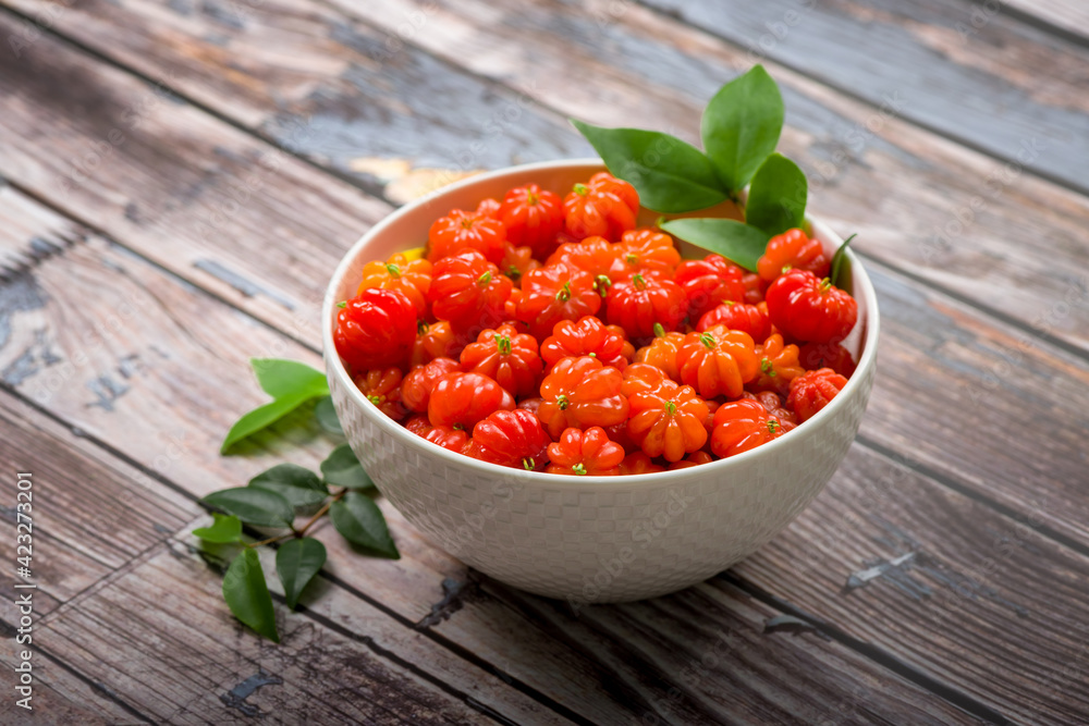Surinam cherry in a white bowl on a wooden table. Surinam cherry in a white bowl on a wooden table.