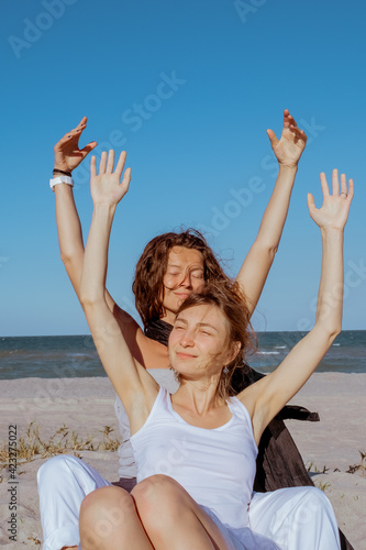 Happy gay couple spending happy time together. Couple of lesbians have fun on the beach. Beautiful women friends relaxing outside. Lifestyle lesbian couple concept.
