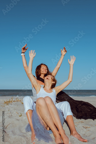 Happy gay couple spending happy time together. Couple of lesbians have fun on the beach. Beautiful women friends relaxing outside. Lifestyle lesbian couple concept.