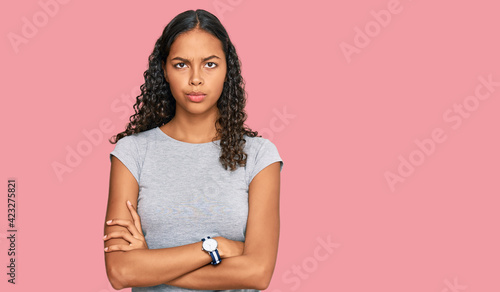 Young african american girl wearing casual clothes skeptic and nervous, disapproving expression on face with crossed arms. negative person.
