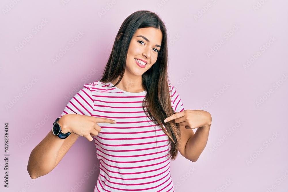 Young brunette woman wearing casual clothes over pink background looking confident with smile on face, pointing oneself with fingers proud and happy. Young brunette woman wearing casual clothes over pink background looking confident with smile on face, pointing oneself with fingers proud and happy.