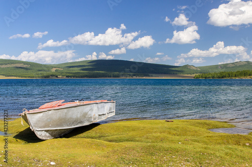 One old boat on the bank of the lake and green forest behind, Khovsgol lake, Mongolia