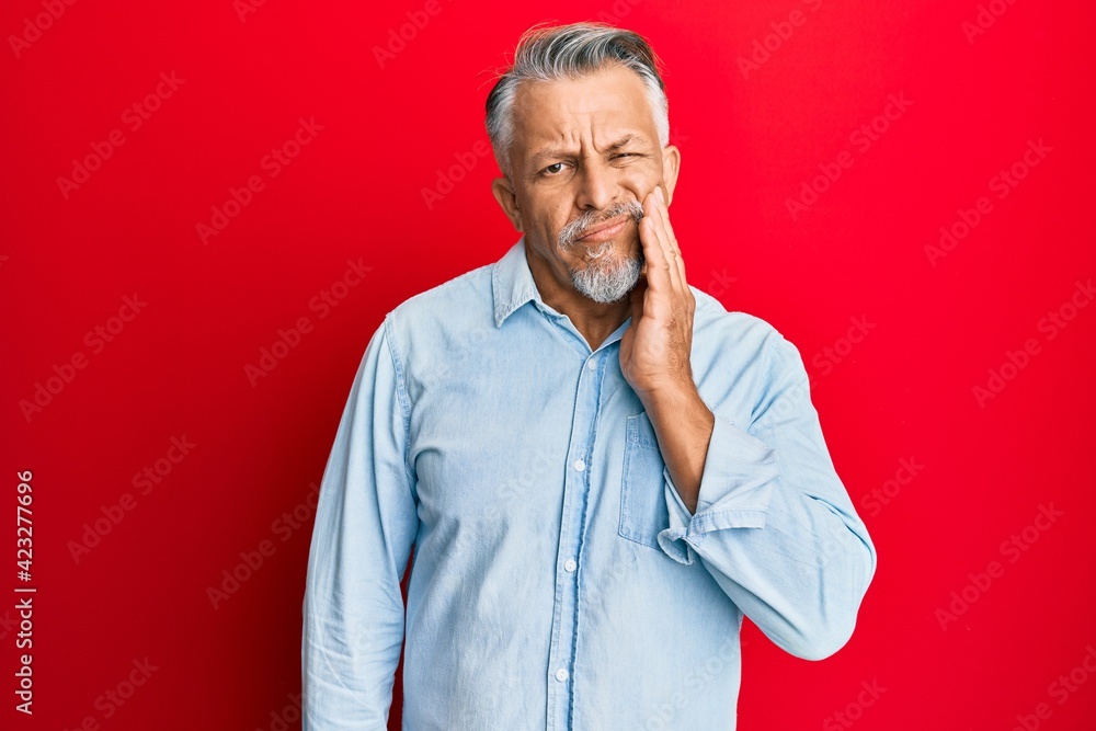 Middle age grey-haired man wearing casual clothes touching mouth with hand with painful expression because of toothache or dental illness on teeth. dentist