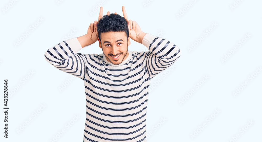 Young hispanic man wearing casual clothes posing funny and crazy with fingers on head as bunny ears, smiling cheerful Young hispanic man wearing casual clothes posing funny and crazy with fingers on head as bunny ears, smiling cheerful
