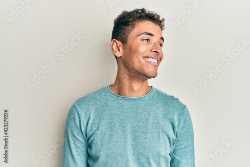 Young handsome african american man wearing casual clothes looking to side, relax profile pose with natural face and confident smile.