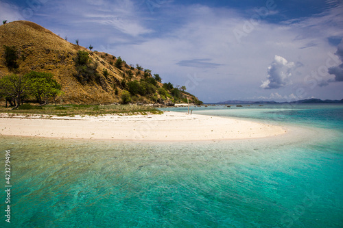 The island with the hill and its white sandy beach going down right into turquoise waters of the clean ocean around, Nusa Tenggara, Indonesia