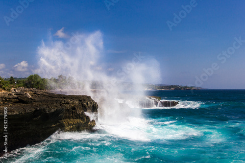 Water aerosol spraying in the air after Powerful waves hitting rocks and spraying the coastline, Indonesia, Nusa Lembongan