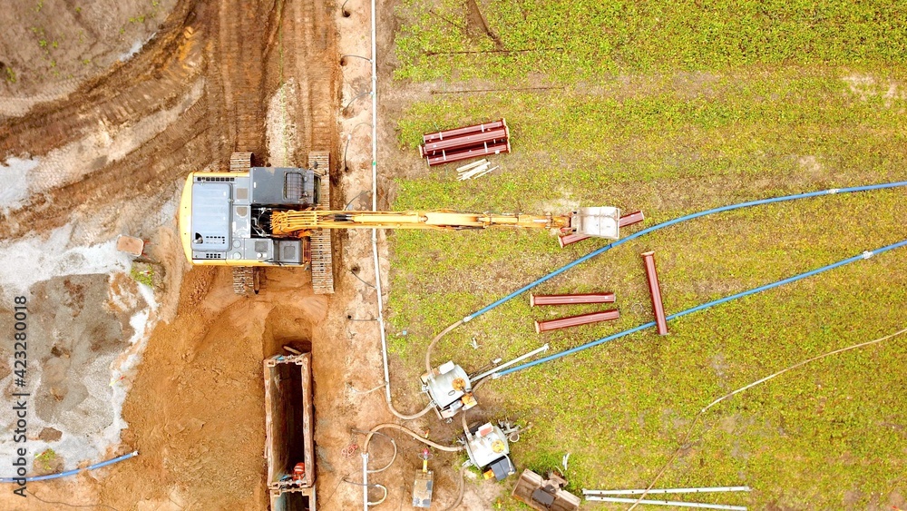 Bagger verlegt einen Kanal um ein Baugebiet zu erschließen, Tiefbau ...