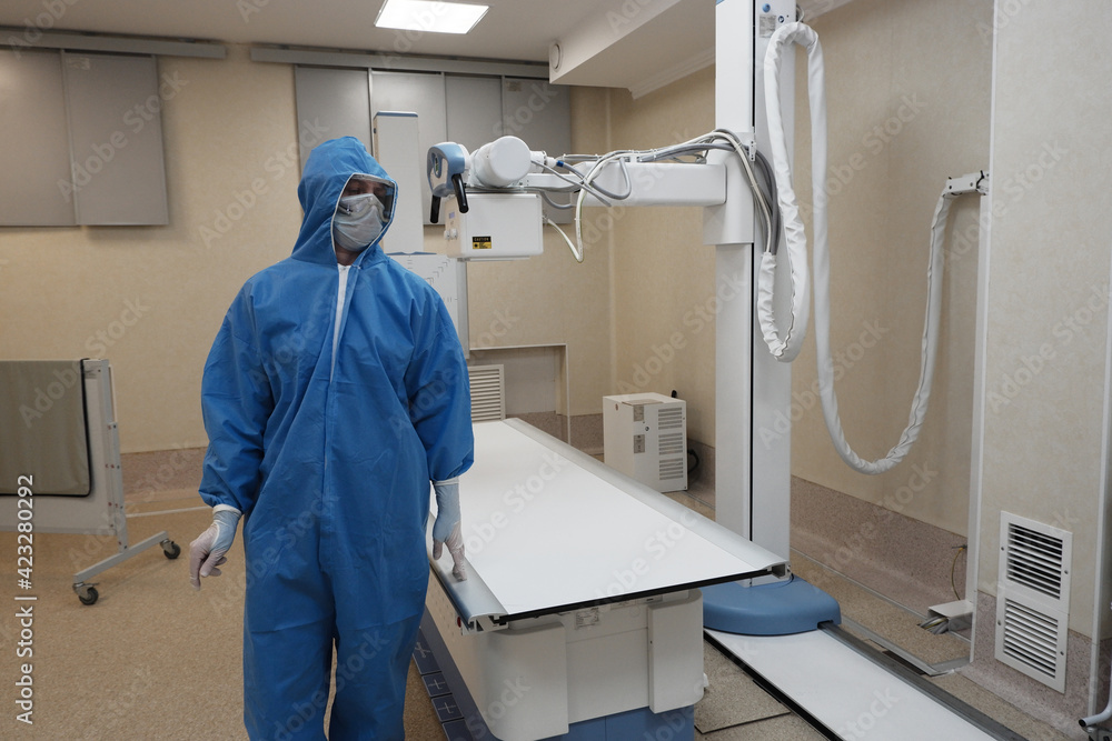 The work of a radiologist in antiviral overalls in the X-ray room for diagnostics. The work of a radiologist in antiviral overalls in the X-ray room for diagnostics.
