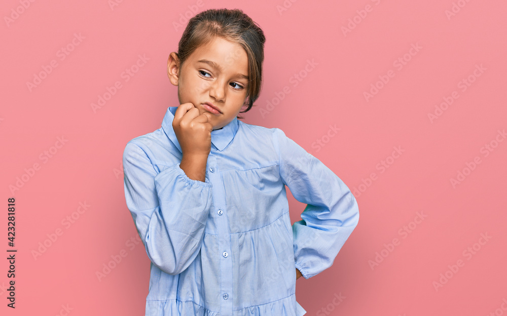 Little beautiful girl wearing casual clothes serious face thinking about question with hand on chin, thoughtful about confusing idea Little beautiful girl wearing casual clothes serious face thinking about question with hand on chin, thoughtful about confusing idea