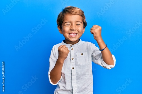 Adorable latin kid wearing casual clothes celebrating surprised and amazed for success with arms raised and eyes closed photo