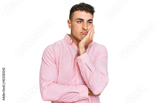 Hispanic young man wearing casual clothes thinking looking tired and bored with depression problems with crossed arms.