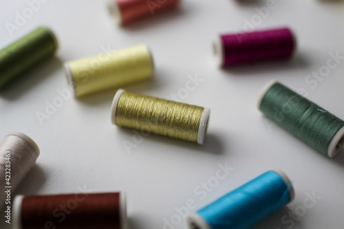 The spools of colorful thread on the white background. Selective focus.