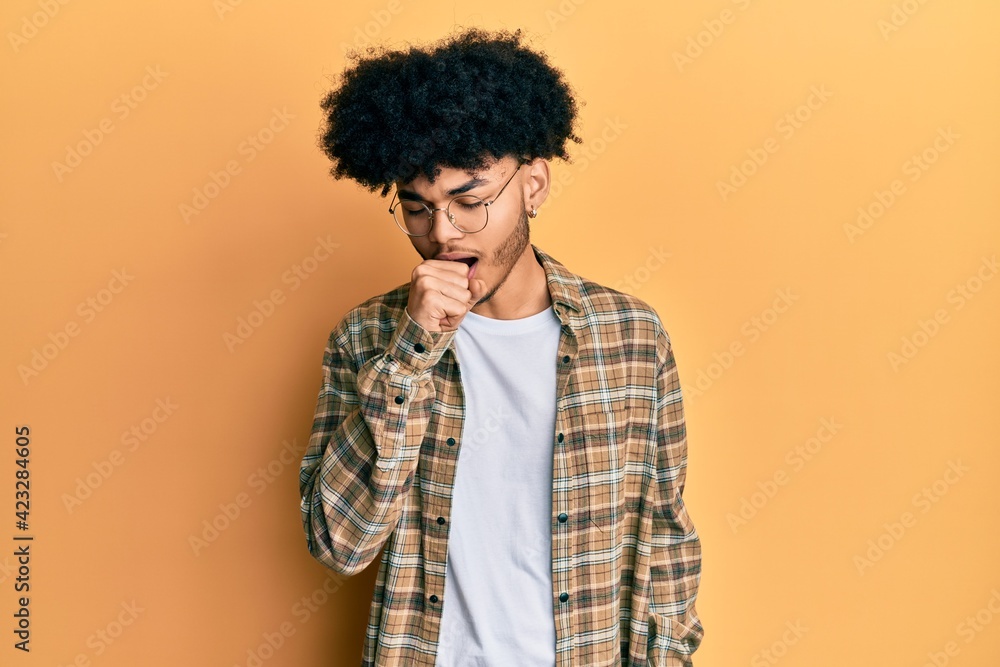 Young african american man with afro hair wearing casual clothes feeling unwell and coughing as symptom for cold or bronchitis. health care concept. Young african american man with afro hair wearing casual clothes feeling unwell and coughing as symptom for cold or bronchitis. health care concept.