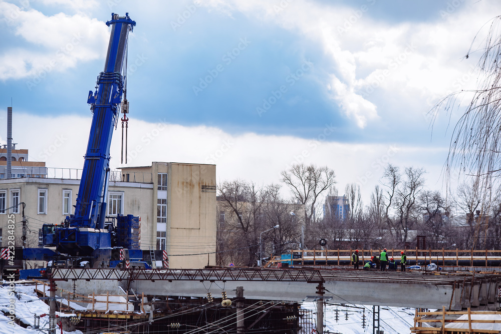 Obraz premium Workers in protective helmets are repairing bridge in Voronezh