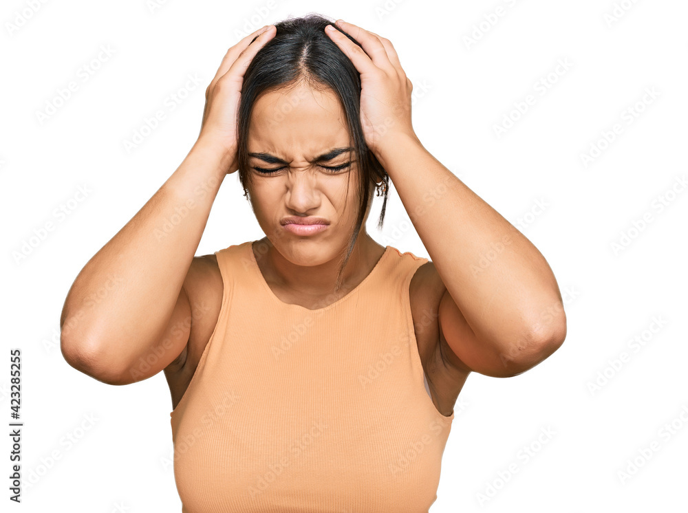Young brunette woman wearing casual clothes suffering from headache desperate and stressed because pain and migraine. hands on head. Young brunette woman wearing casual clothes suffering from headache desperate and stressed because pain and migraine. hands on head.
