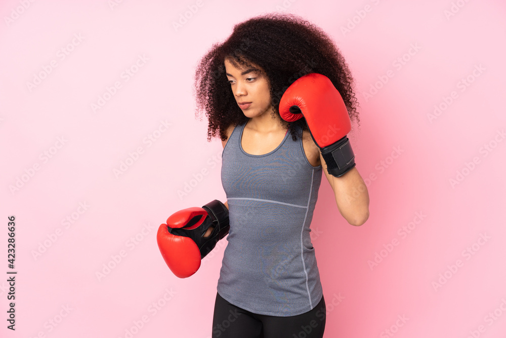Young african american sport woman isolated on pink background with boxing gloves