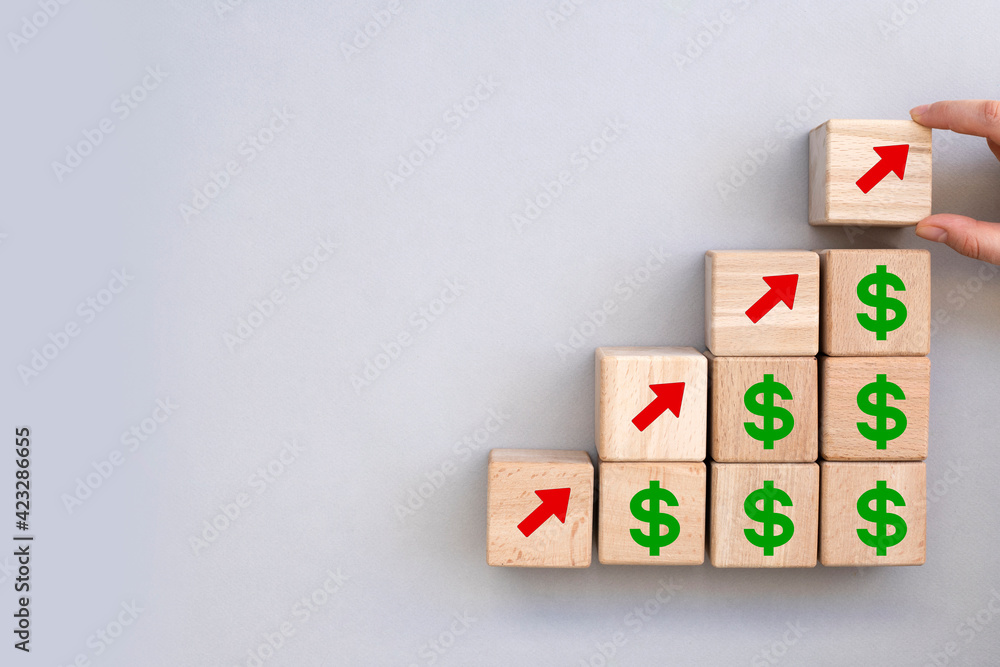 concept of revenue growth. growth on stacked wooden cubes on gray background. Financial or business growth concept. arrows and dollar icons on wooden cubes concept of revenue growth. growth on stacked wooden cubes on gray background. Financial or business growth concept. arrows and dollar icons on wooden cubes