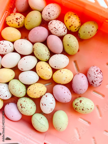 Chocolate eggs, Easter sweets, on a pastel red background, top view with copy space