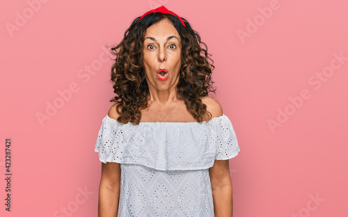 Obraz na plátně Middle age hispanic woman wearing casual clothes scared and amazed with open mou