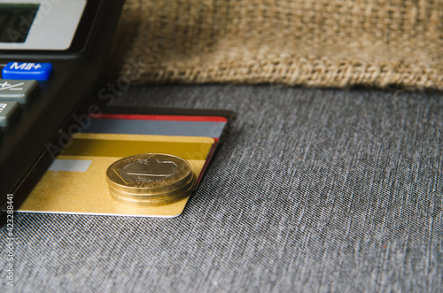 Credit card amongst coins of yellow metal photo
